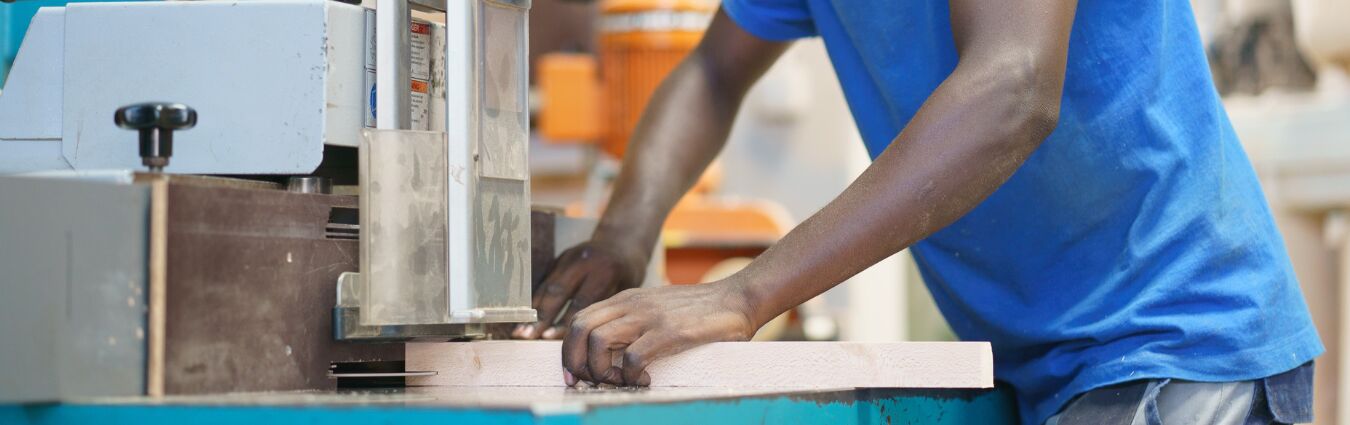 Ausbildung Schreinerhandwerk in Ruanda - Mann bedient große Säge in Schreinerei